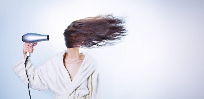 Mujer secándose el pelo