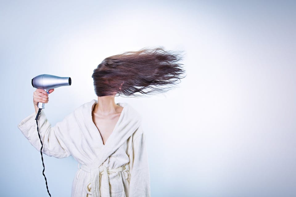 Mujer secándose el pelo